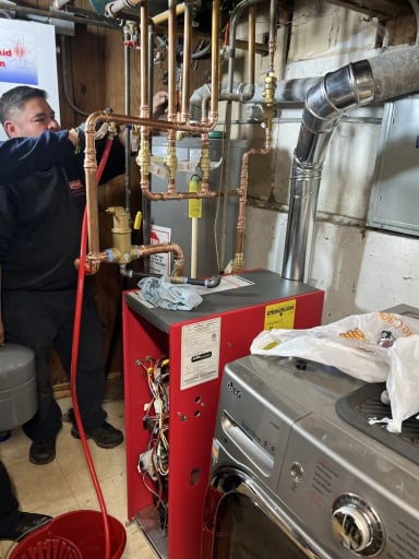 Technician working on heating system with copper pipes